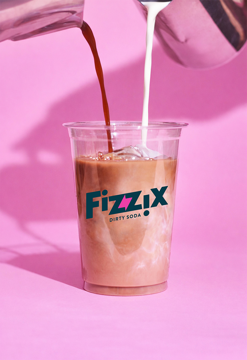 Dirty soda being built — soda and cream poured over ice into a branded Fizzix cup